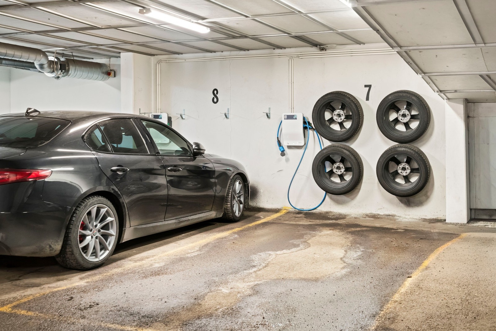 Parkeringsplass medfølger kjøpet - elbillading via app og praktisk hjuloppheng på vegg Galleribilde