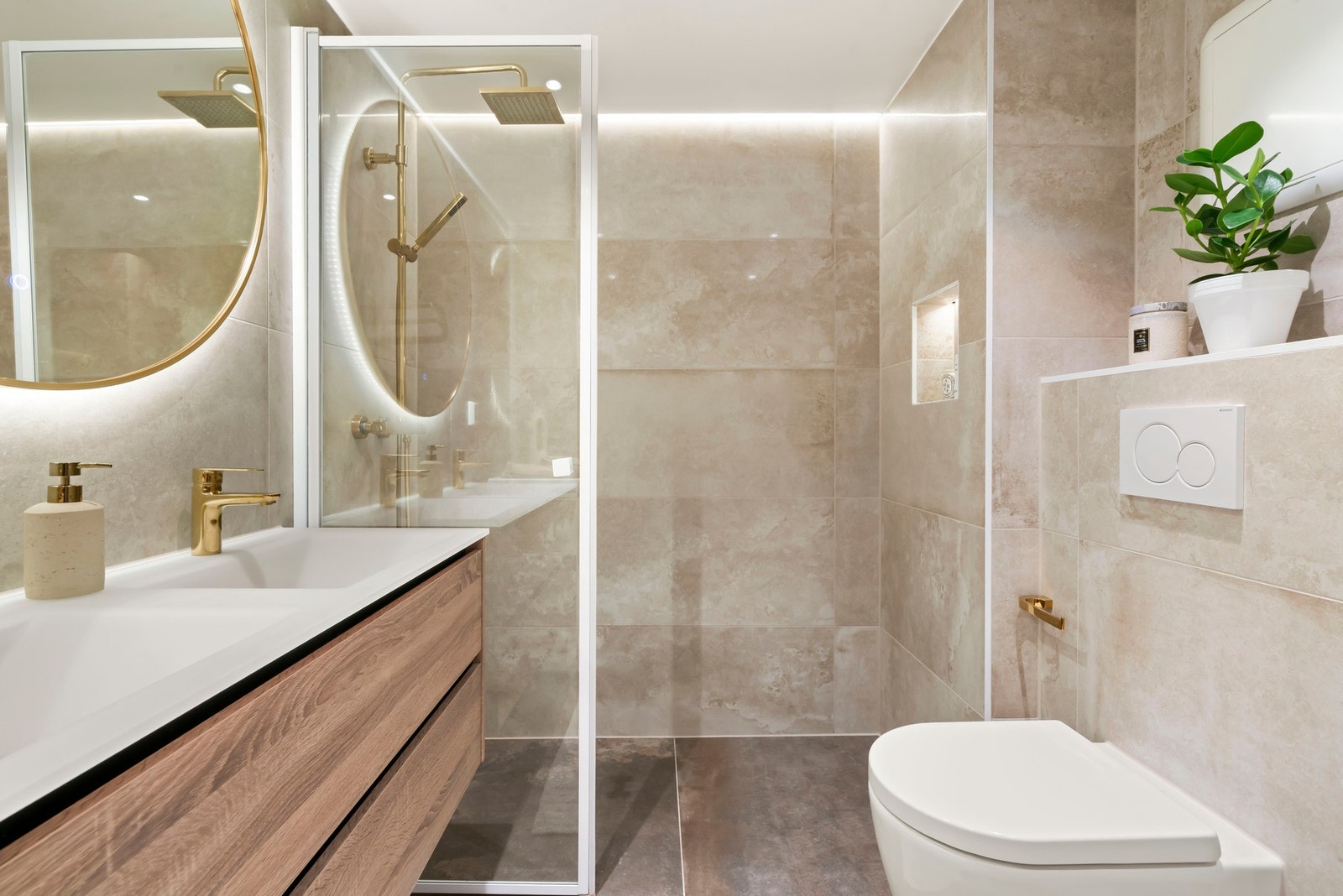 Stor dusjsone med svingbar glassvegg og dusjarmatur i gull med både hånd- og
regnfallsdusj. Innfelt nisje med skjult belysning og ledstripe i himling Galleribilde