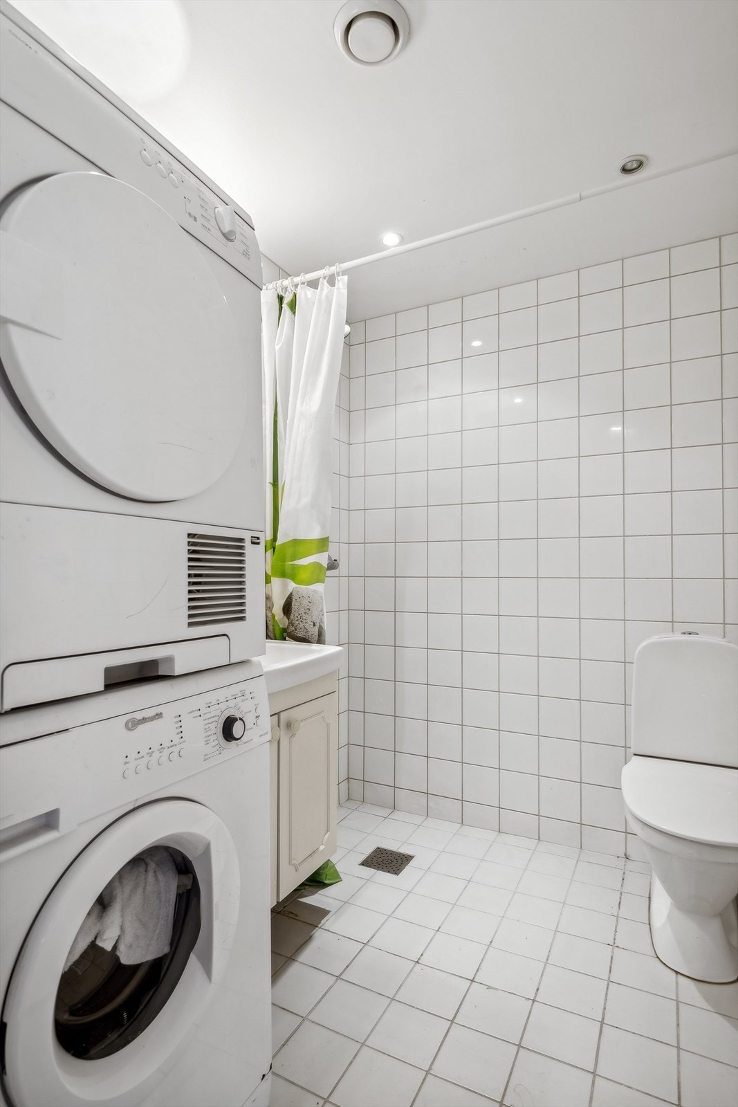 Badet fra 2007 har flislagte overflater og gulvvarme. Rommet er innredet med servant i skap, gulvmontert toalett og dusjhjørne. Galleribilde