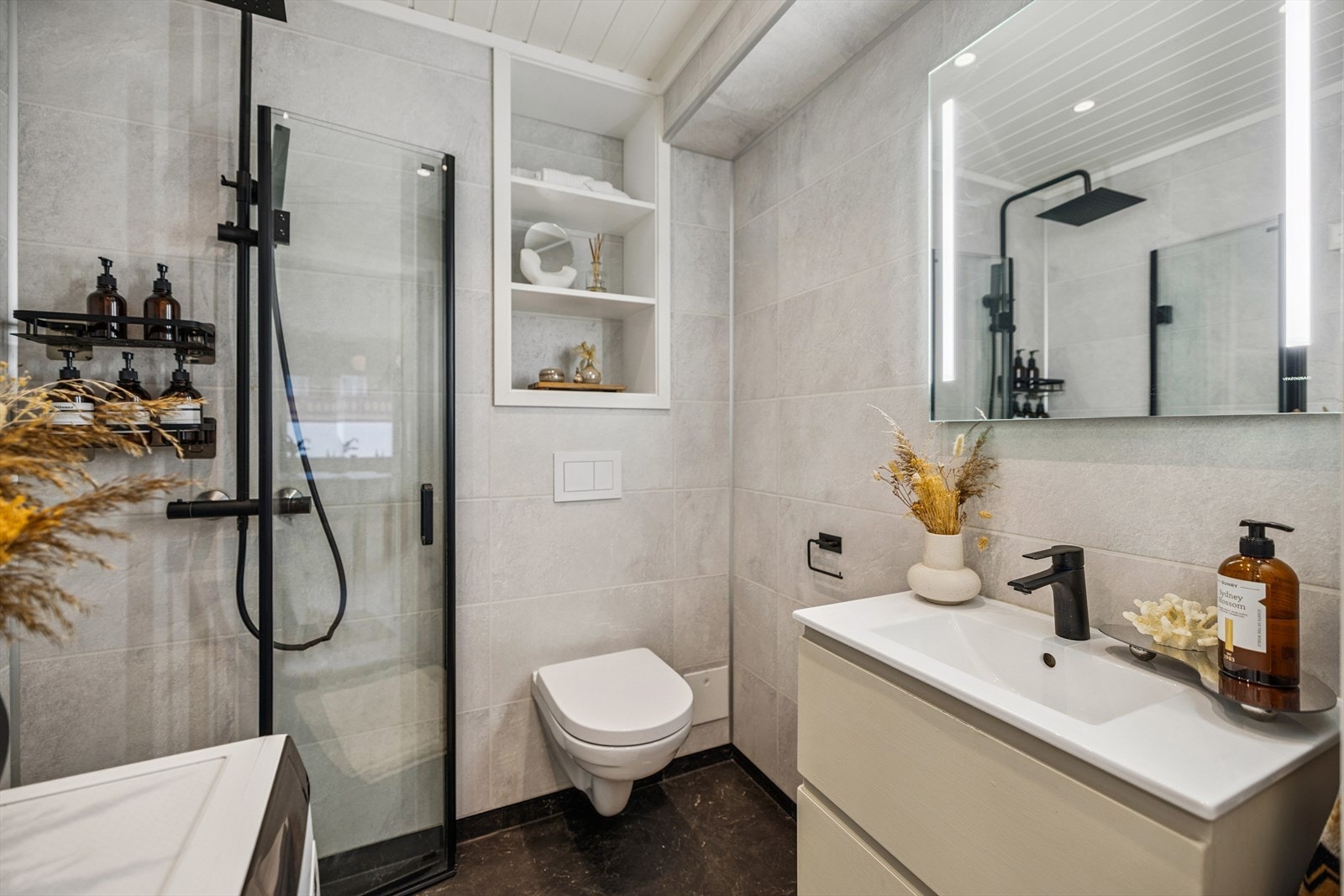 Praktisk dusjhjørne med innfellbare vegger og en moderne servantinnredning. Galleribilde