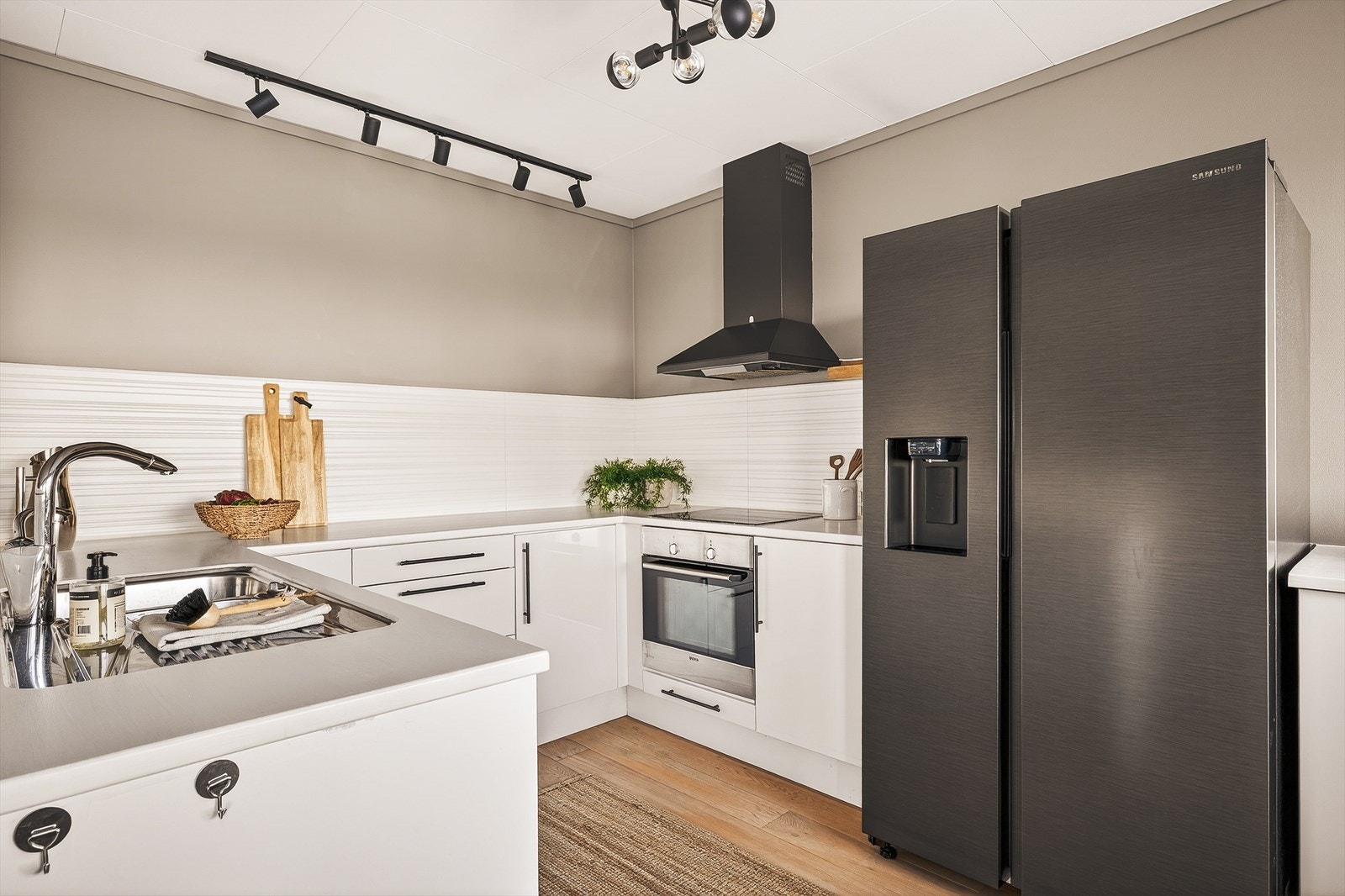 Kjøkkenet er romslig og tidløst med hvite glatter fronter og benkeplate av heltre, overmalt. Delikat kjøkkenplate over benkeplate som står i fin kontrast til vegg. Galleribilde