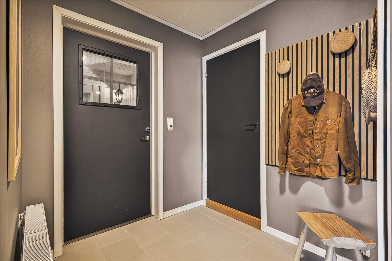 En entré med fliser som gjør det enkelt å holde rent, særlig når små og store kommer inn fra uteaktivitet. Galleribilde