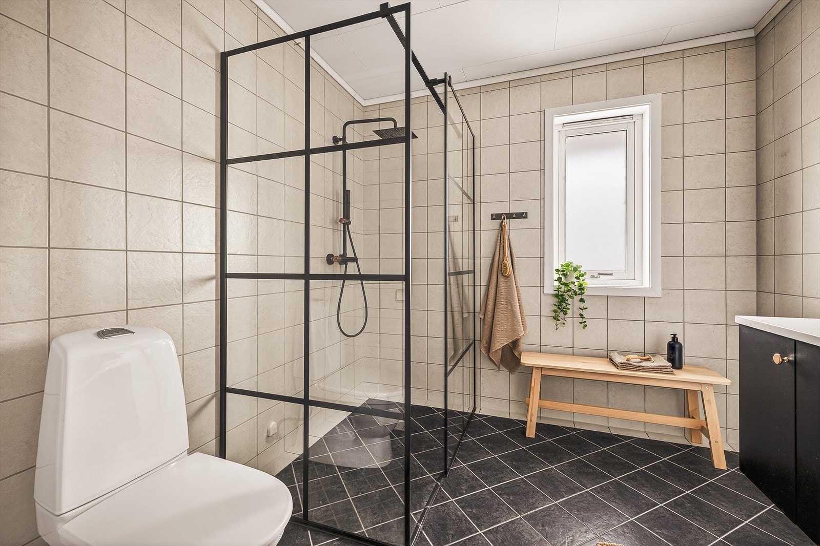 Baderom er innredet med nedfelt servant m/skap og speil, toalett, og dusjhjørne. Galleribilde