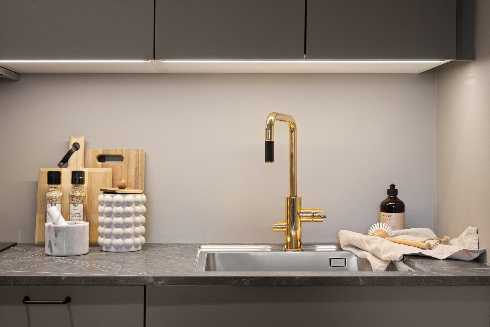 Lekre detaljer som blandebatteri i messing/gull og underlimt servant. Galleribilde