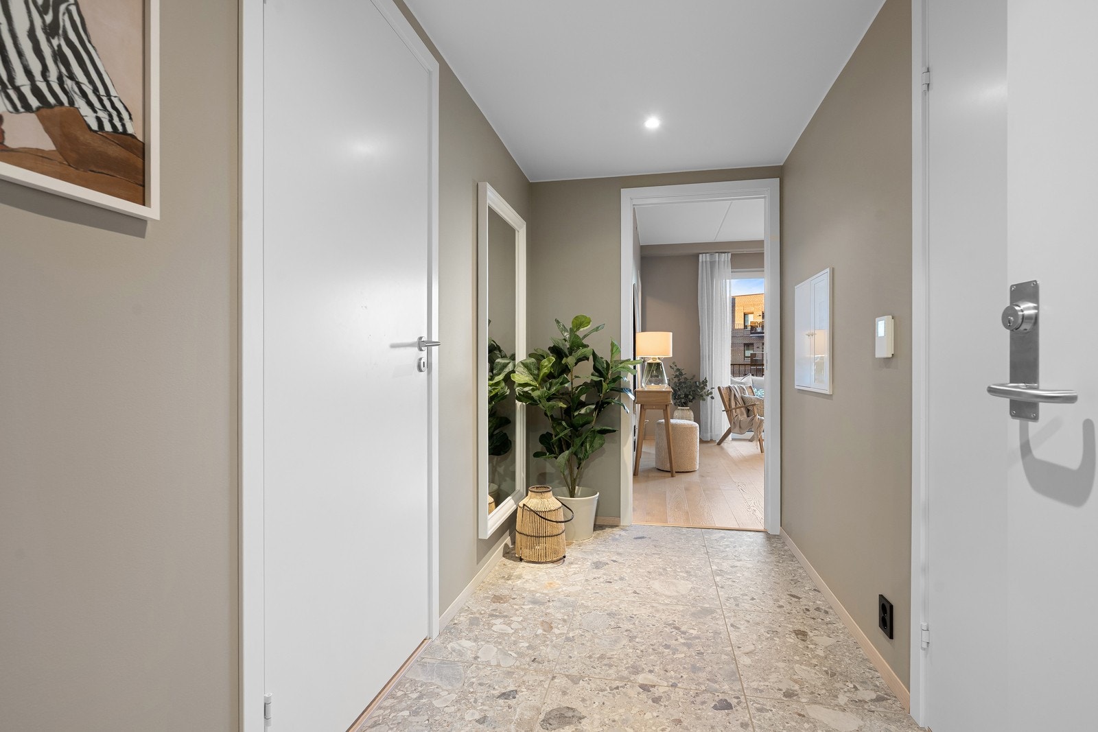 Velkommen inn i entréen. Lekre fliser på gulvet og downlights i taket. Galleribilde