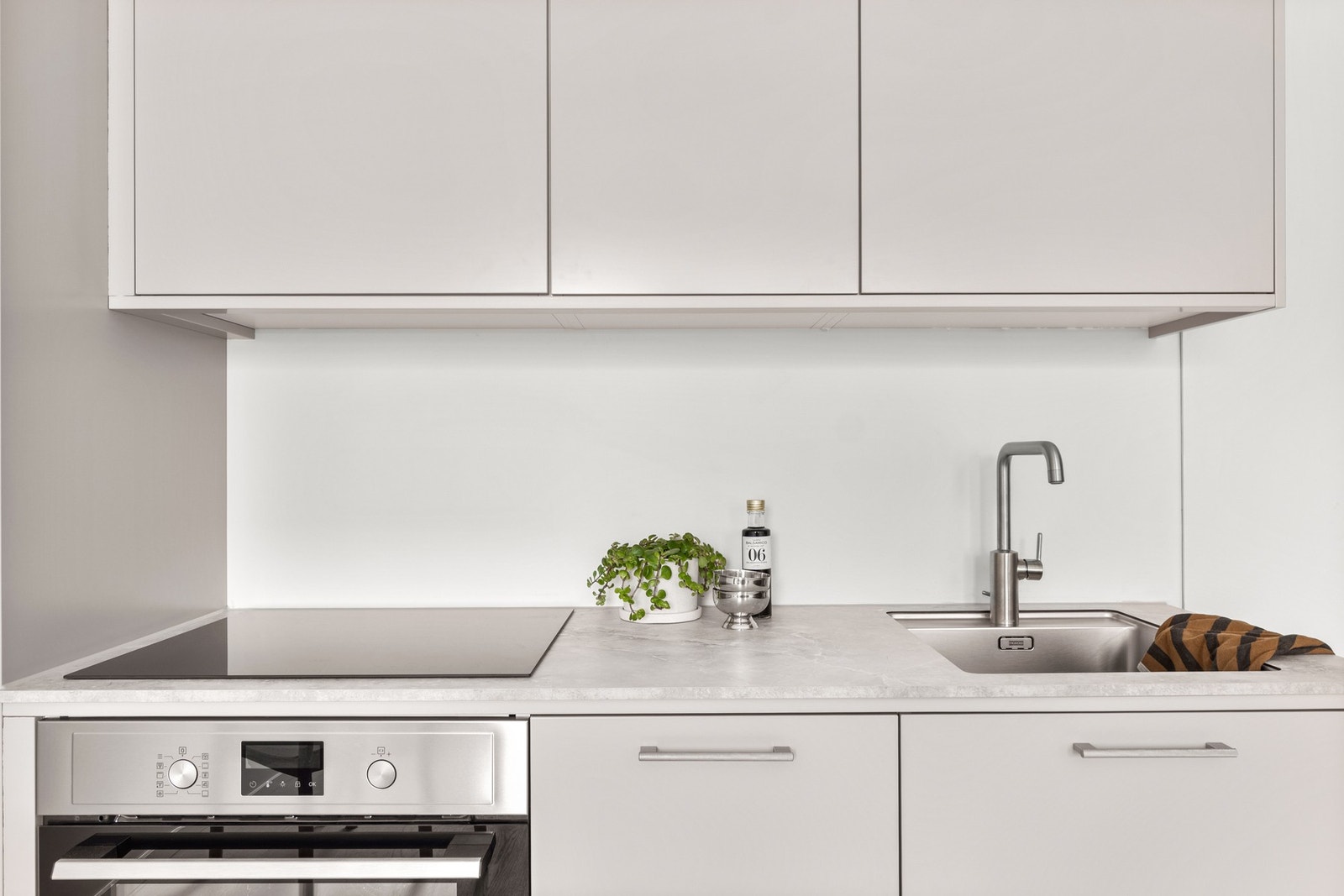 Kjøkkeninnredningen har glatte fronter med stekeovn, platetopp, kjøl/frys og oppvaskmaskin alt integrert i innredningen. Galleribilde