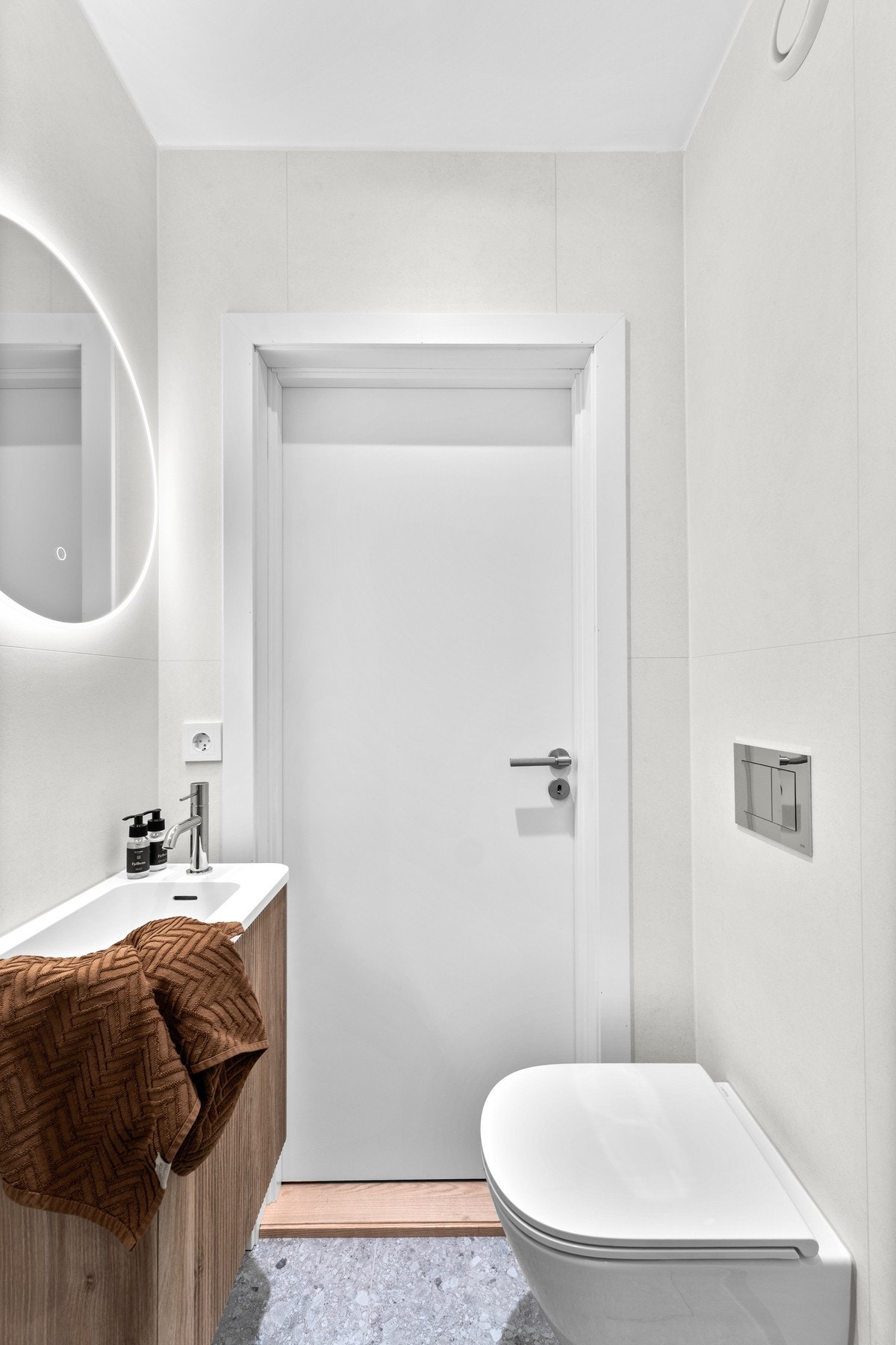 Badet har tidløse fliser med elektrisk gulvvarme, regnfallsdusj og vegghengt klosett. Benkeskap med glatte fronter og speil over servant. Galleribilde