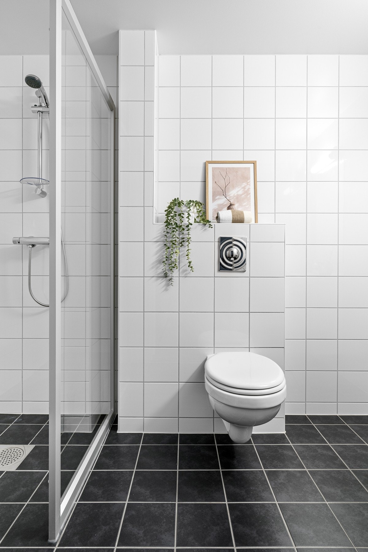 Bad nr. 2/gjestebad har fliser på gulv og vegger og er innredet med toalett, servant på skapseksjon og speil. Galleribilde