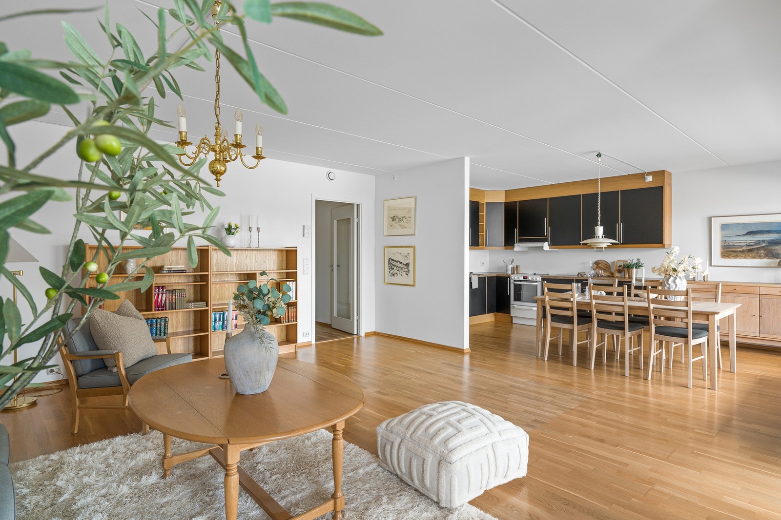 Den åpne løsningen gir god plass til sofa, tv-seksjon og spisebord ved kjøkkensonen. Galleribilde