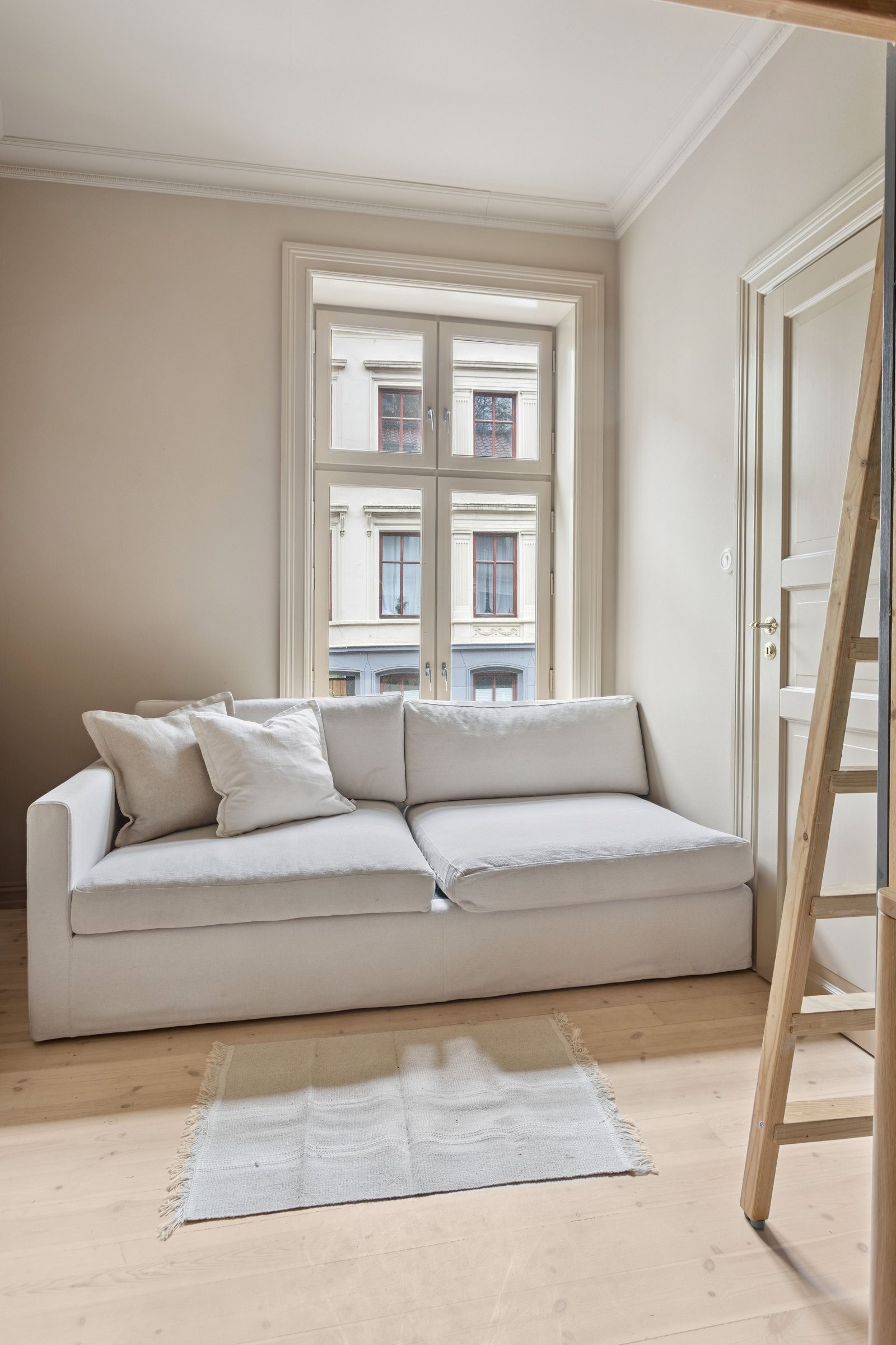 Det er plass til sofa eller seng under det store luftige vinduet, som gjør at man kan skape en liten stue, kosekrok eller ekstra plass til gjester. Galleribilde