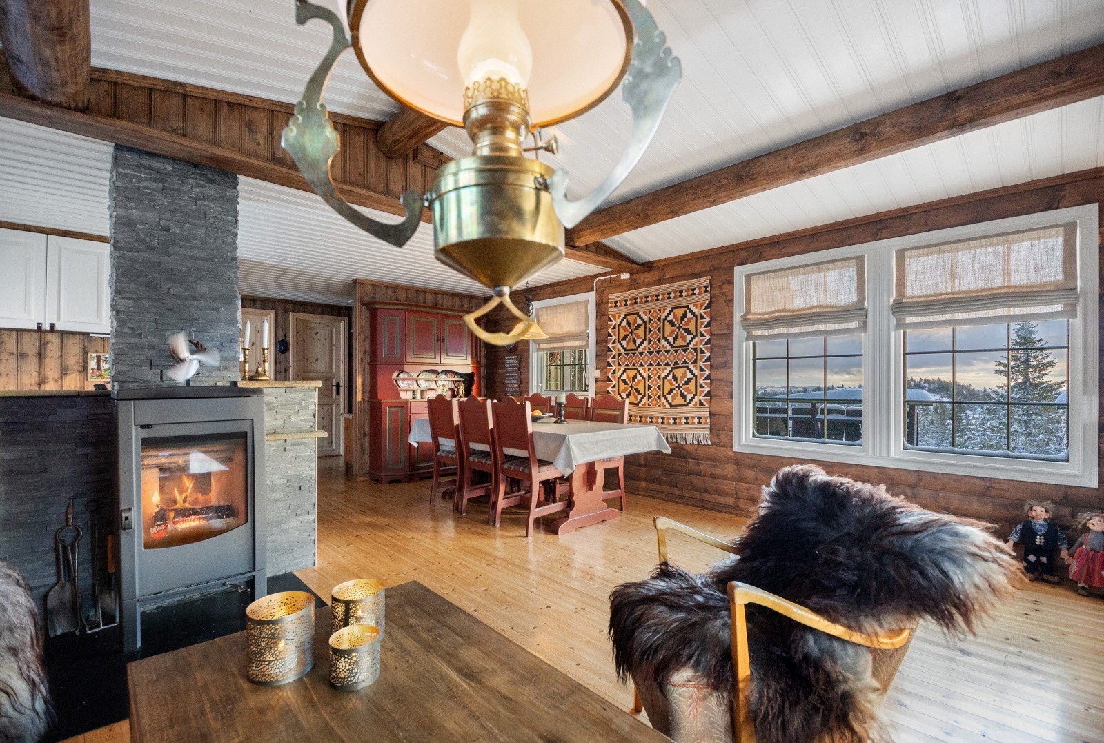 Koselig hytte med peisovnen plassert midt i rommet som bidrar til god varme rundt i hytta. Galleribilde