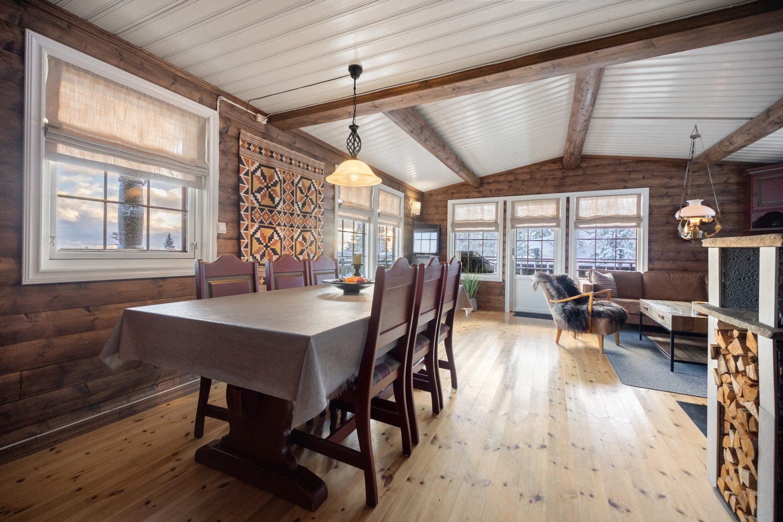 Hytta har en åpen og innbydene stue- og kjøkkenløsning med peisovn i midten, noe som gjør det ekstra sosialt og hyggelig. Galleribilde