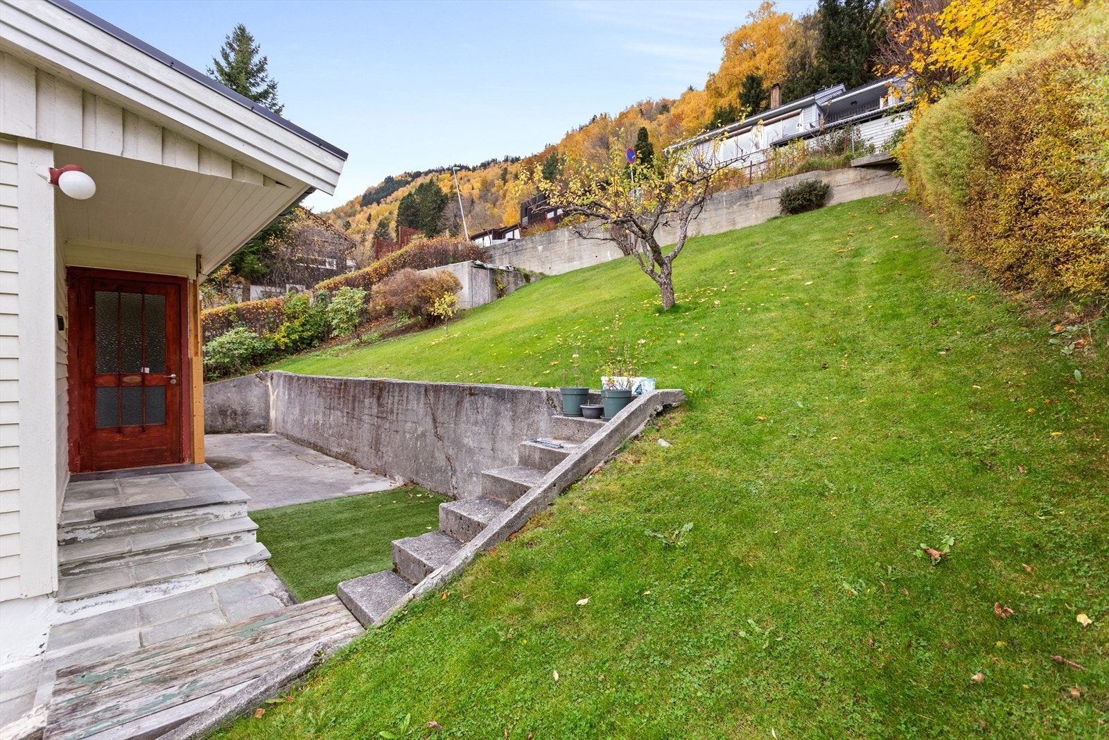 Tomta er opparbeid med hageanlegg som plen og ulike buskvekster. Galleribilde