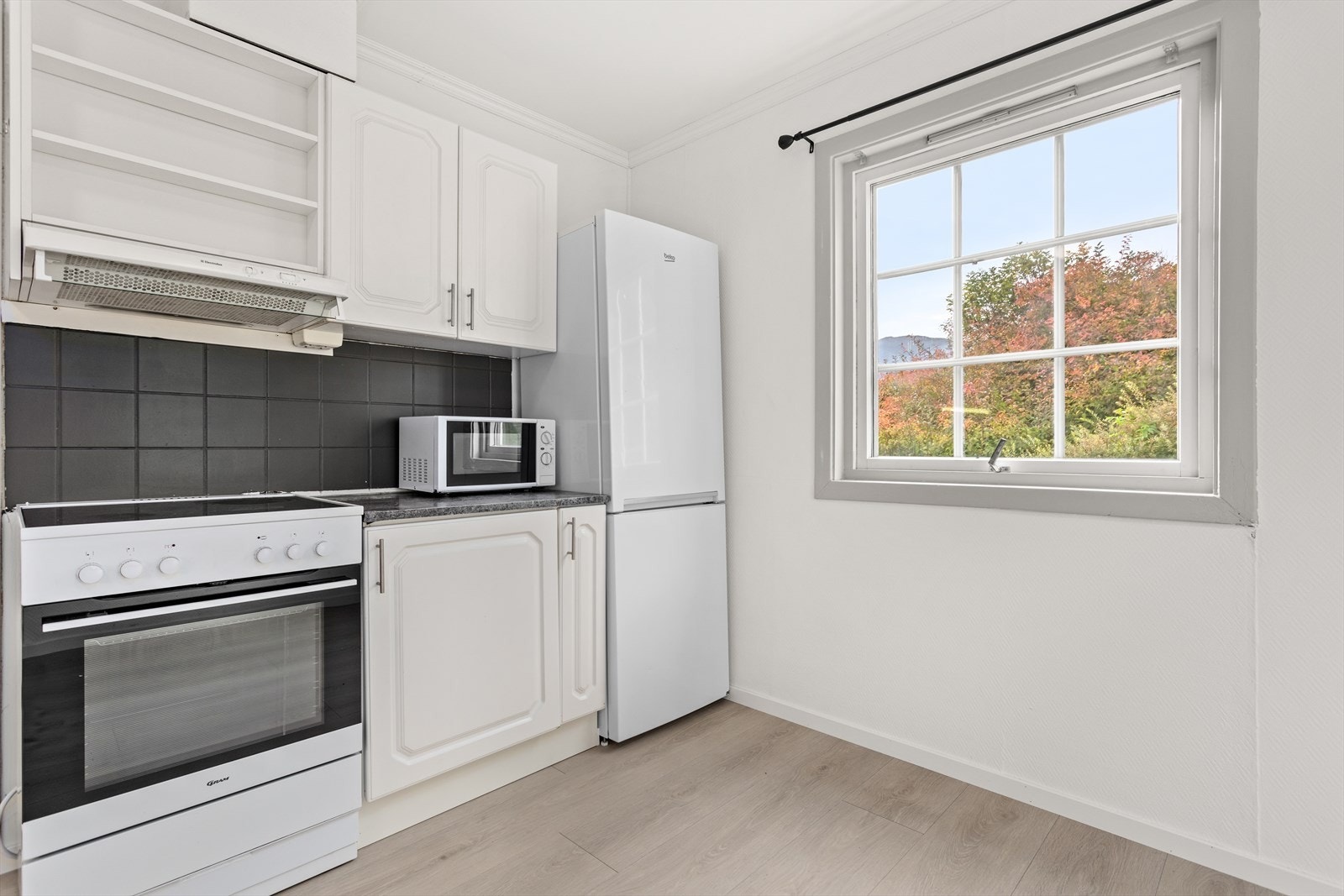 Møbelfrontane er kvite og profilerte, og benkeflate er av laminat. På del av innredningen er det sprutsikring av flis på vegg. Galleribilde