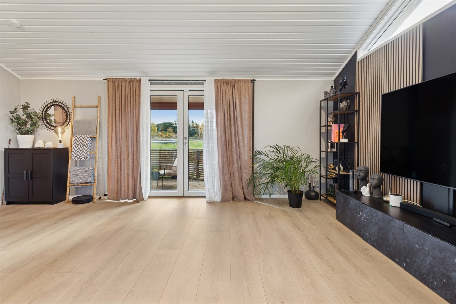 Fra stuen er det utgang til en flott veranda som gir plass til utemøbler, og skaper en naturlig overgang mellom inne- og uteområdene- Galleribilde