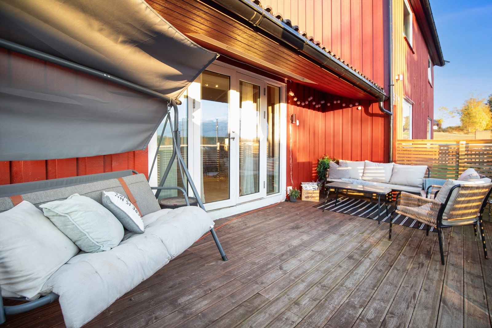 Koselig veranda der man kan skape sin egen oase med grønne planter, sittegruppe og hyggelig belysning. Galleribilde