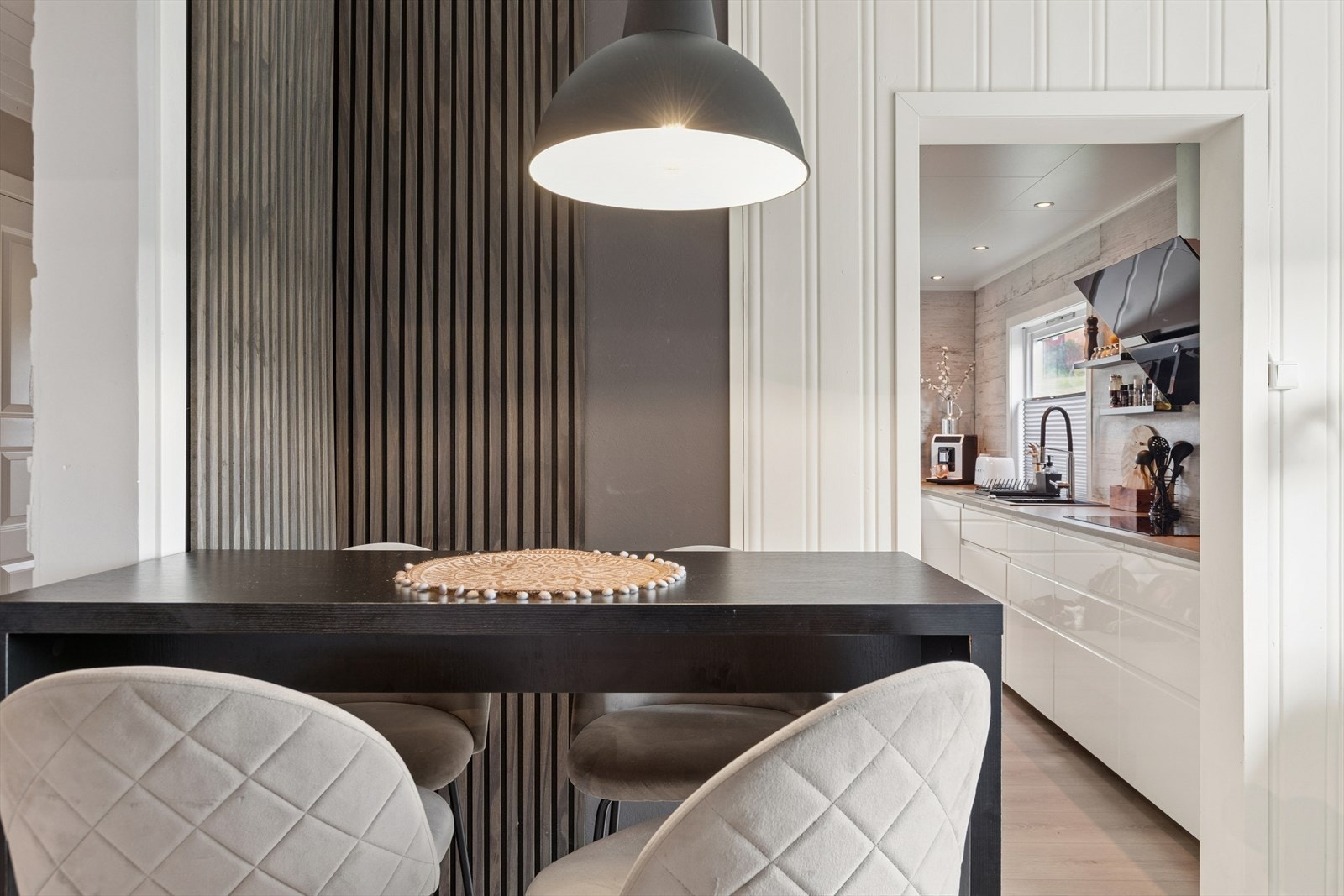 En moderne og stilig spiseplass som gir ekstra sitteplasser og binder kjøkkenet sammen med resten av rommet på en elegant måte. Galleribilde