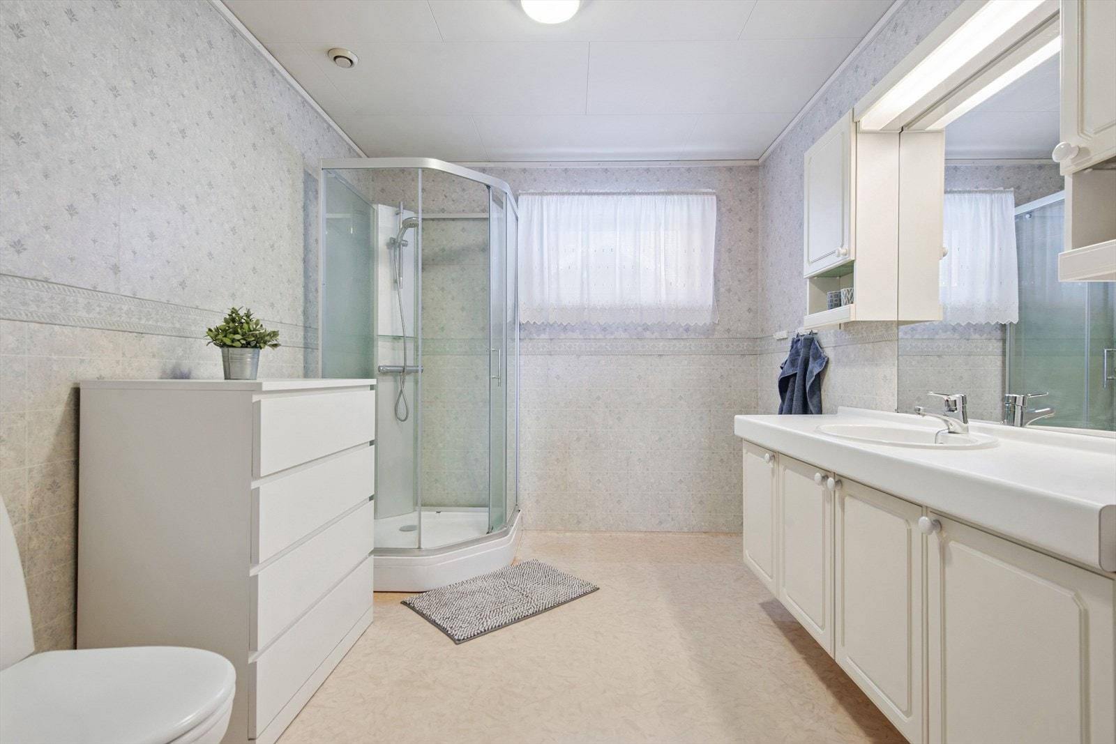 Badet er utstyrt med dusjkabinett, servant med underskap og varme i gulvet. Galleribilde