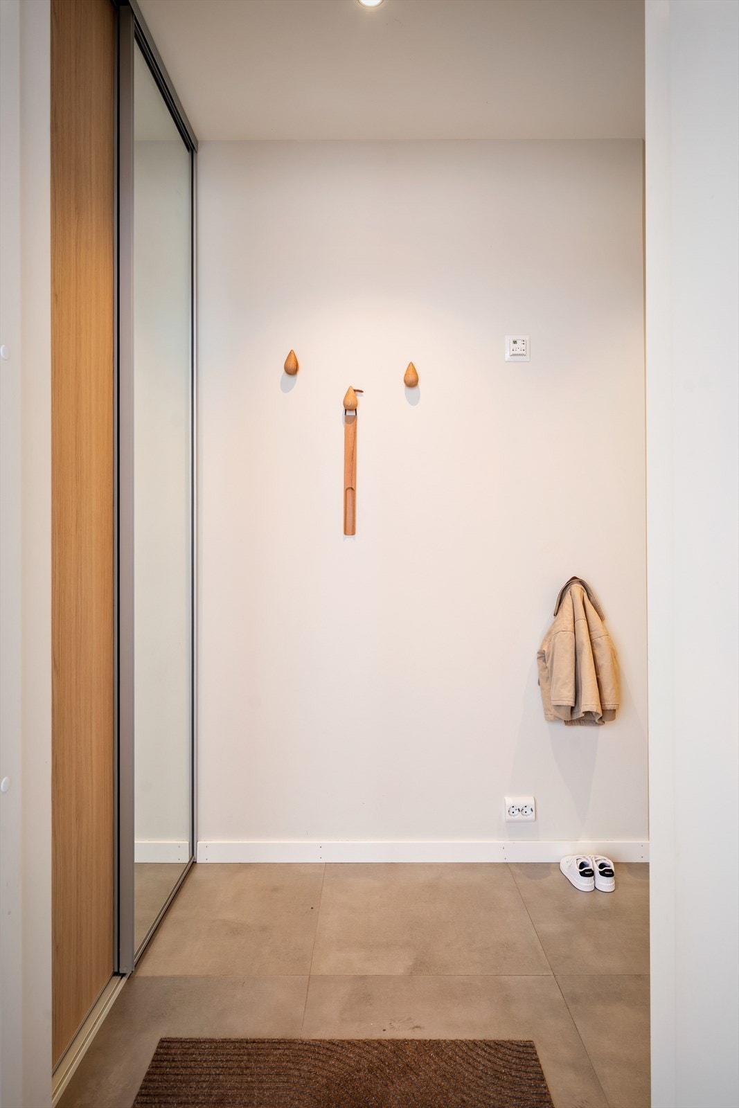 Velkommen inn! Entreen er innredet med skyvedørsgarderobe for oppbevaring av klær og sko. Galleribilde
