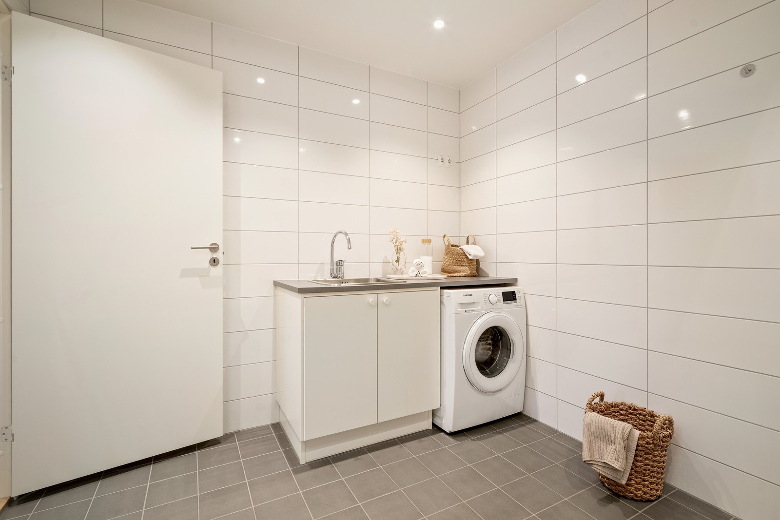 Det er tilrettelagt med en praktisk arbeidsbenk med skyllekum og opplegg for vaskemaskin, noe som gir gode løsninger for både daglig bruk og klesvask. Galleribilde