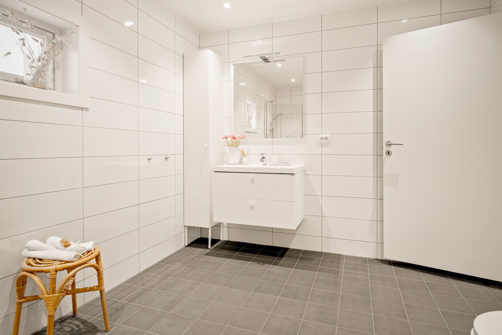 Rommet er utstyrt med en servantinnredning, veggmontert toalett og et dusjhjørne med dusjvegger. Galleribilde