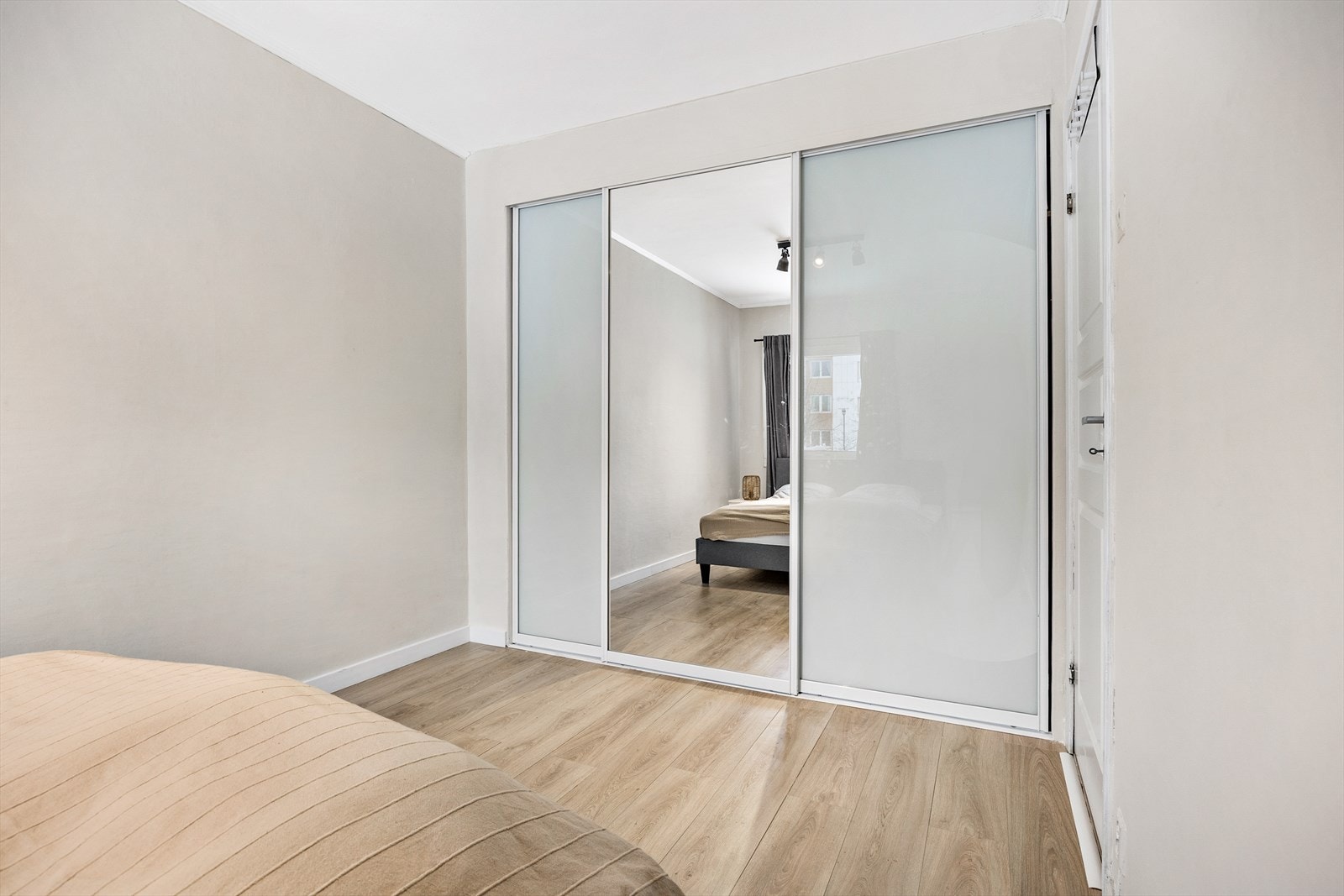 En stor skyvedørsgarderobe med speilfronter gir rikelig med oppbevaringsplass. Galleribilde