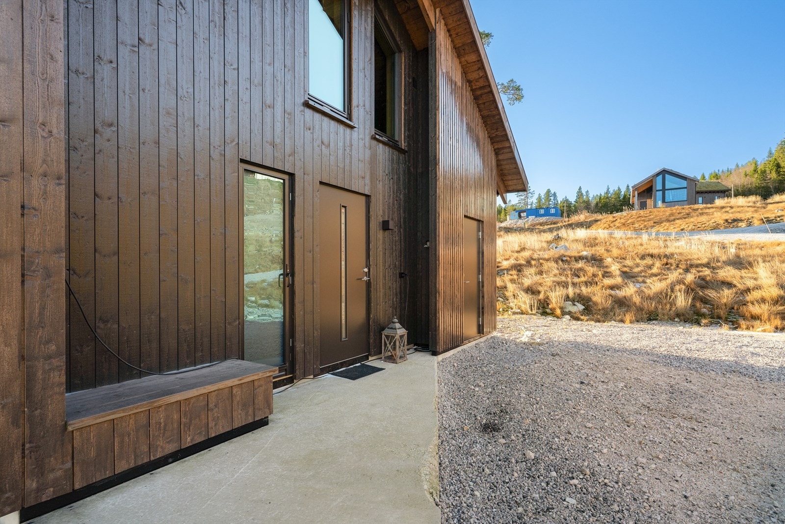 Ved inngangspartiet er det også tillaget en koselig uteplass med sittebenk. Her er det også en kjekk bod/ skiskap.
Begge uteplassene har støpt dekke og er til sammen 19 kvm store. Galleribilde