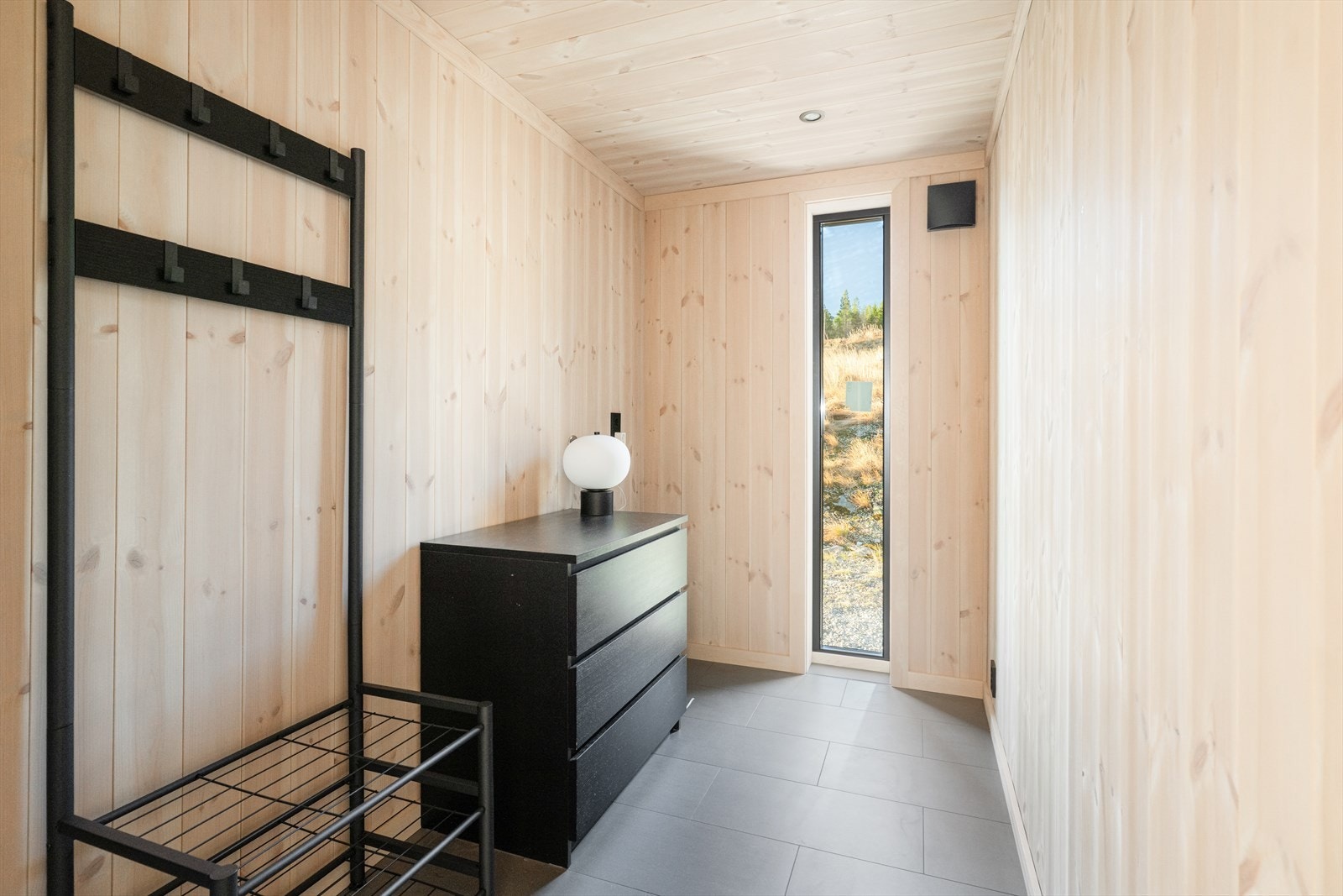 I tilknytning til entreen har fritidsboligen et praktisk garderoberom med god plass til oppbevaring og opplegg for vaskemaskin. Det er montert lekkasjestopper med sensor ved vaskemaskin, men rommet har ikke sluk og er ikke utført som et våtrom. Galleribilde