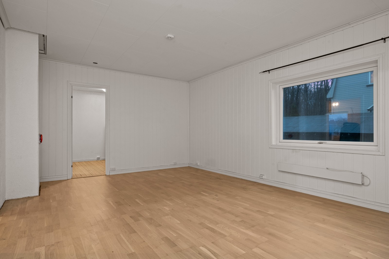 Et stort vindu bidrar med lys til rommet og gir utsyn mot nærområdet. Galleribilde