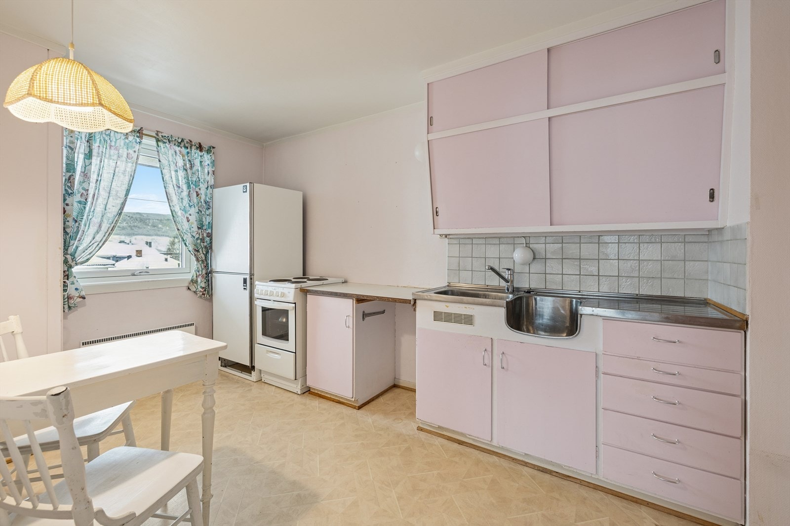 Kjøkkenet har en eldre, opprinnelig innredning med glatte fronter og benkeplate i laminat. Galleribilde