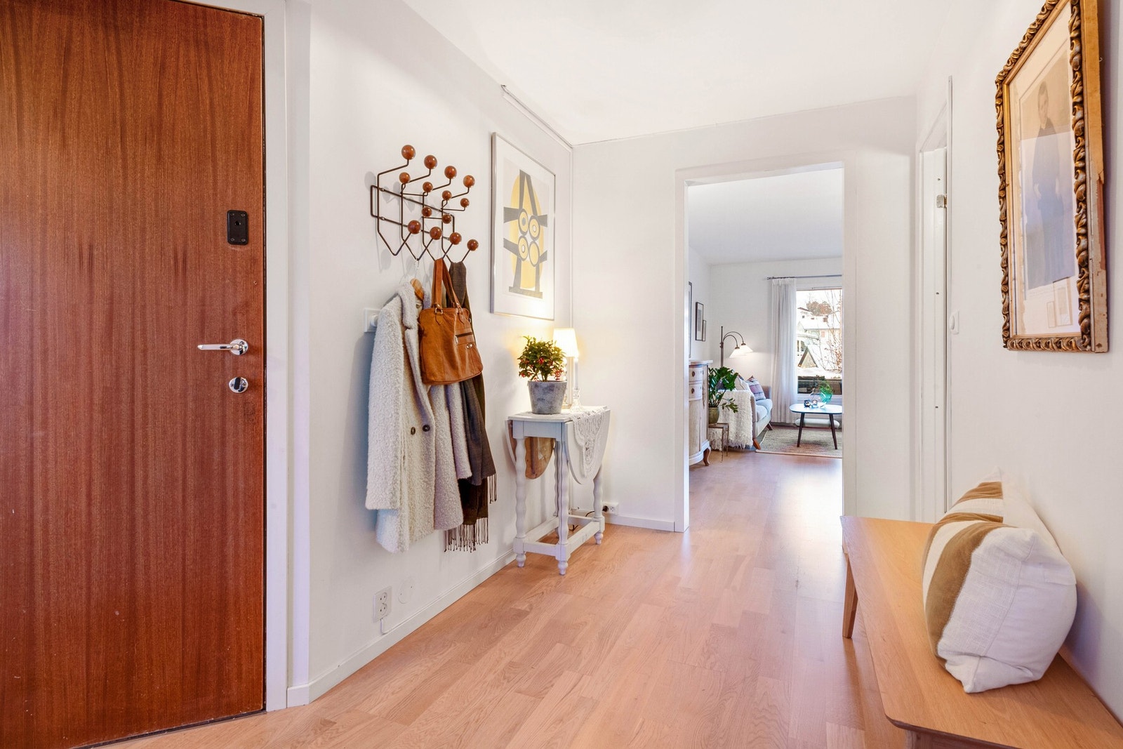 Velkommen inn. Entreen har god plass til klær og sko. Parkettgulvet i bøk videreføres inn i stuen. Galleribilde