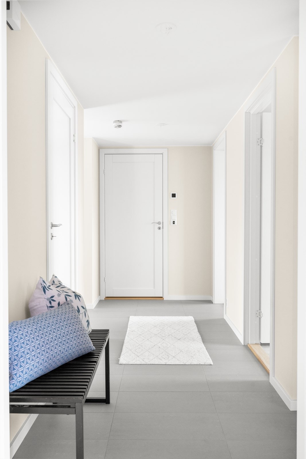 Velkommen inn i flislagt entré med plassbygget skyvedørsgarderobe Galleribilde