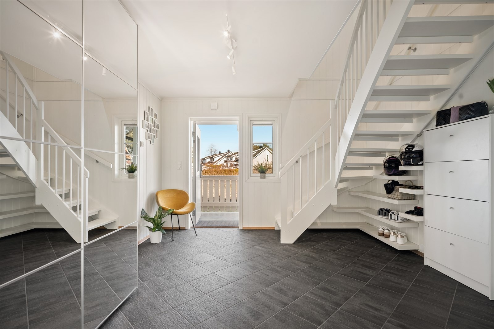 Innenfor døren ønsker en lys og luftig entré velkommen inn. Her er det god plass til å plassere sko og henge fra seg yttertøy i en lekker skyvedørsgarderobe. Galleribilde