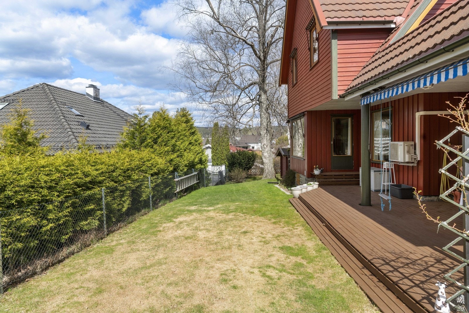 Hagen har en gressplen, terrasse og et gjerde med hekk som gir privatliv. Galleribilde