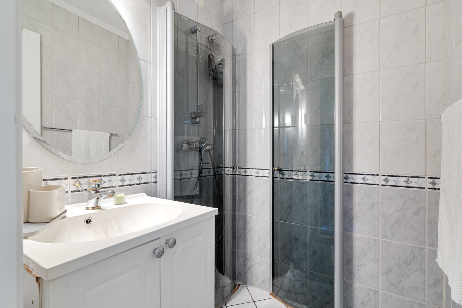 Flislagt baderom fra 2011 med plassbesparende innfellbare dusjdører og baderomsinnredning. Galleribilde