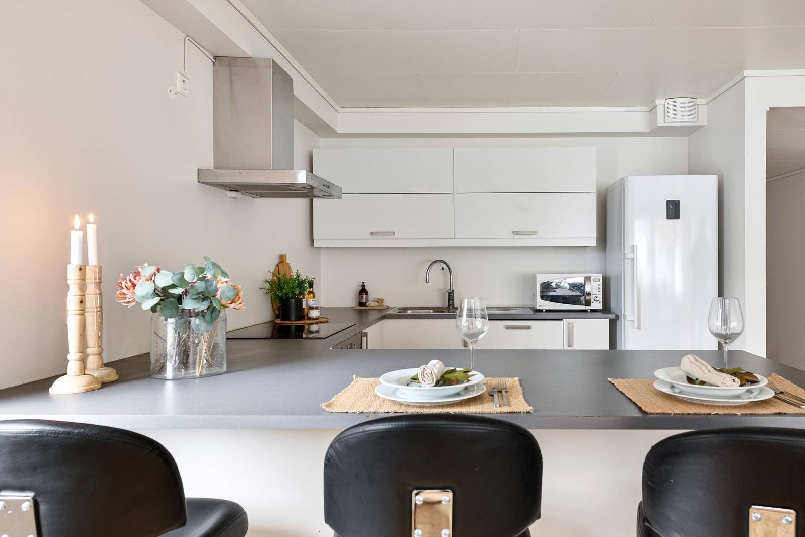 Kjøkkenet er utstyrt med integrert stekeovn, platetopp, oppvaskmaskin og vegghengt ventilator med komfyrvakt Galleribilde