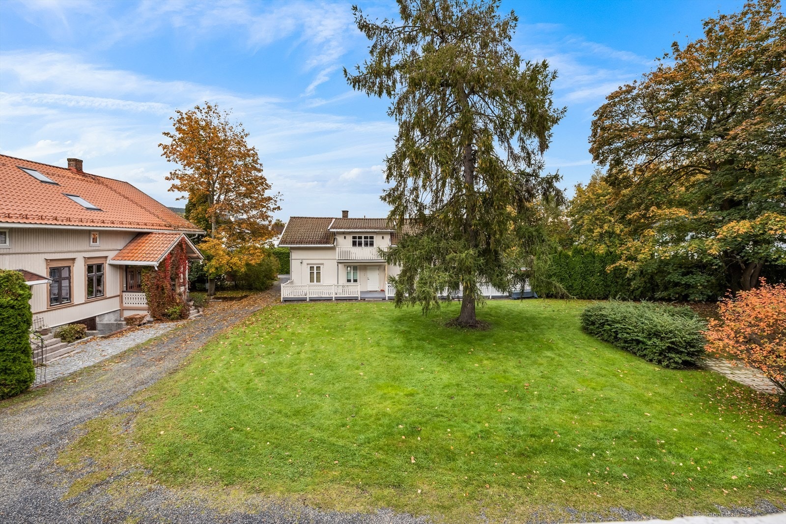 Tomten er pent opparbeidet med gressplen og beplantning. Galleribilde