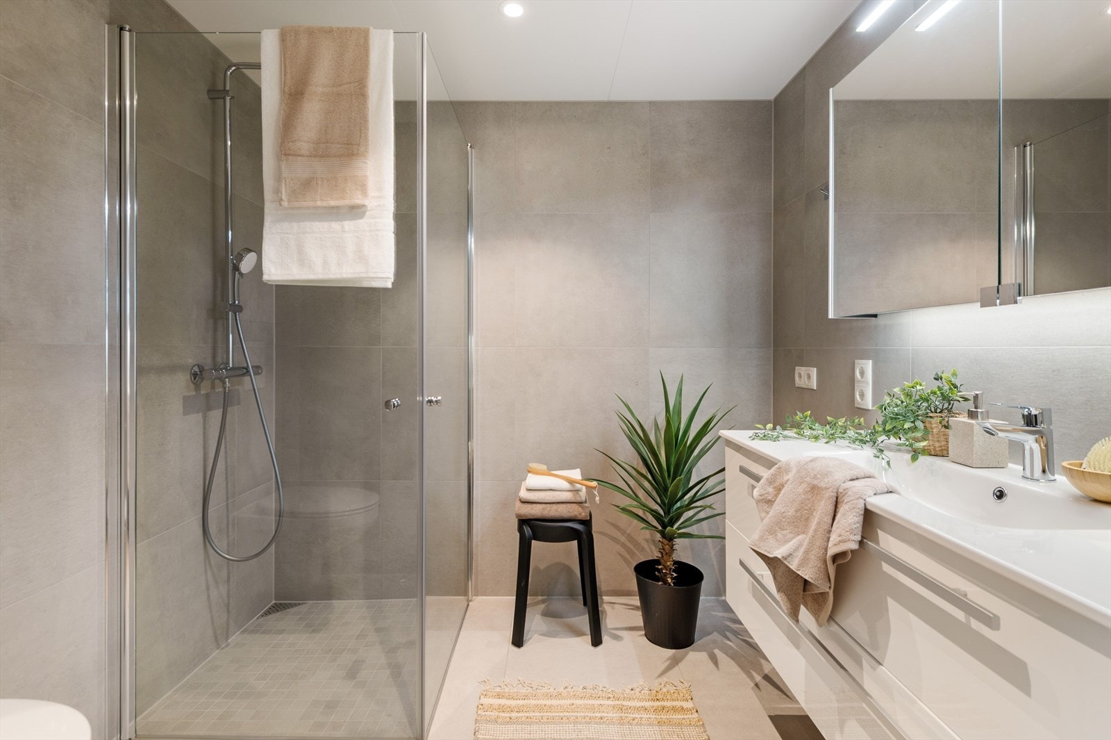 Moderne bad med duse og delikat fliser samt gulvvarme og downlights. Galleribilde