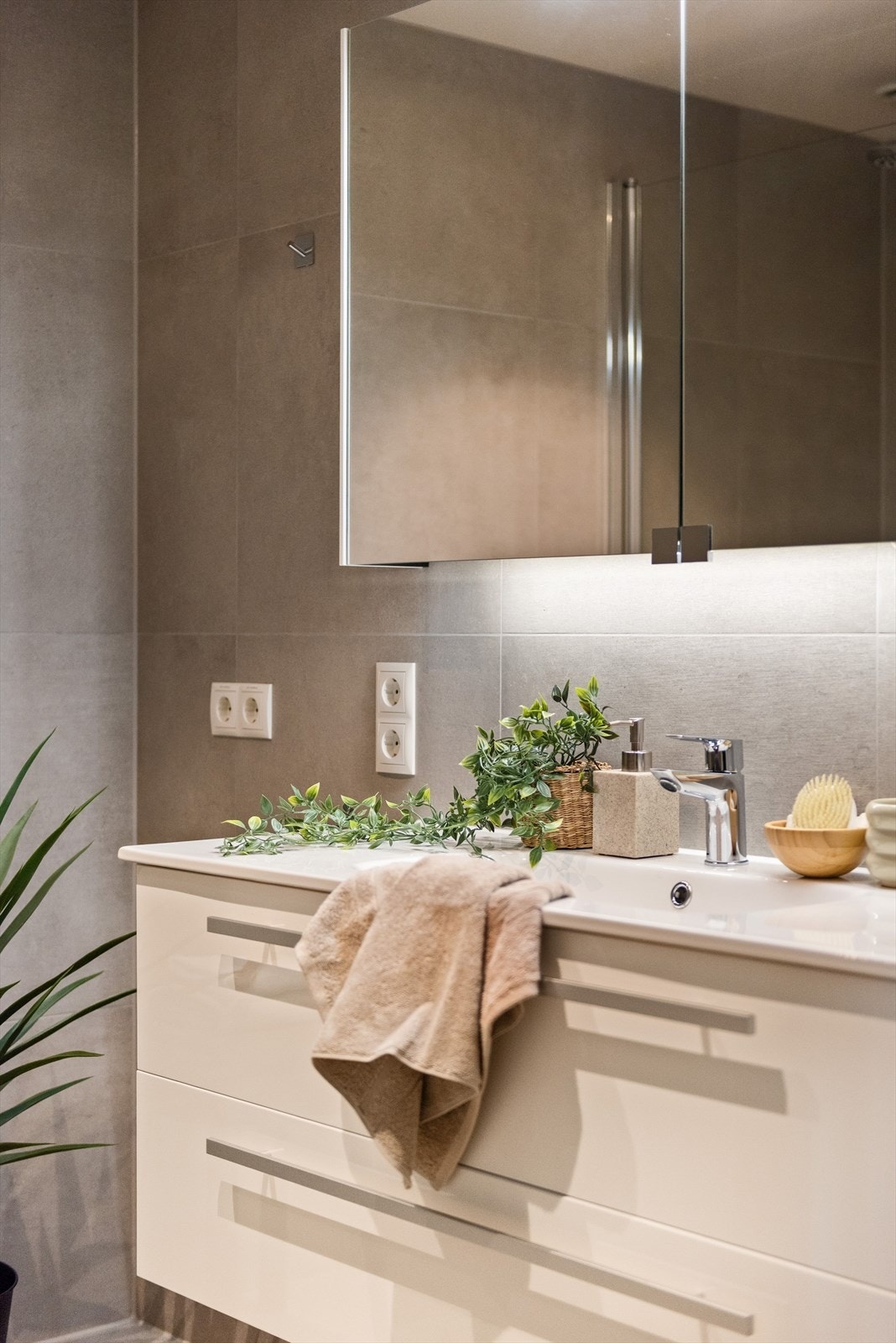 Badet er innredet med vegghengt wc, servantinnredning med skuffer, speilskap, dusjhjørne samt opplegg for vask/tørk. Galleribilde