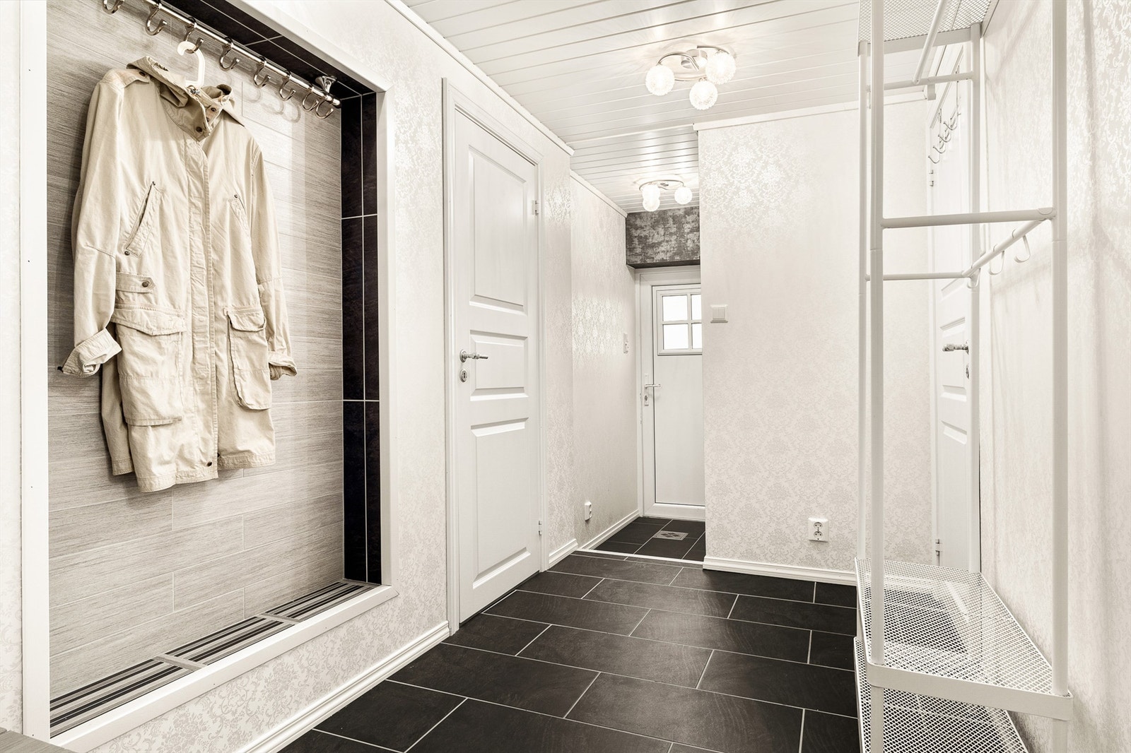 Gangen har flislagt gulv med gulvvarme og leder inn til vaskerom. Døren til venstre fra hoveddel innredet u-etg. Galleribilde