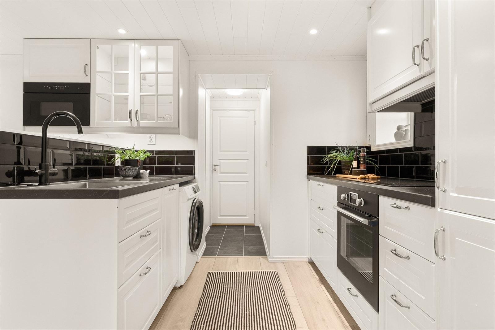 Moderne kjøkkeninnredning med profilerte fronter og laminat benkeplate. Kjøkkenet er innredet med platetopp, stekeovn, mikro, oppvaskmaskin og vaskemaskin. Alle hvitevarer medfølger. Galleribilde