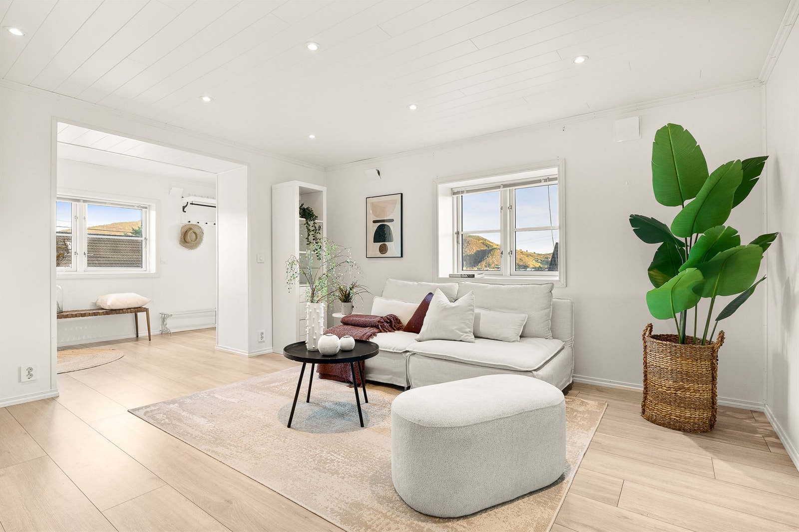 Innbydende og lyst med laminat på gulv, lysmalte overflater og downlights i himling. Galleribilde