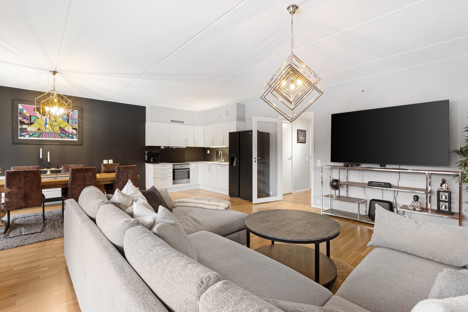 Lys og romslig stue med parkettgulv og malte, slette flater. Åpen løsning mot kjøkken gir gode møbleringsmuligheter og naturlig samlingspunkt i boligen. Galleribilde