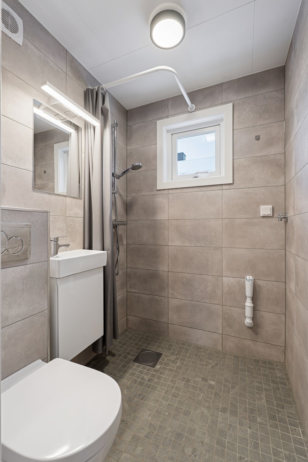 Baderommet har flislagte vegger og gulv med elektriske varmekabler. Galleribilde