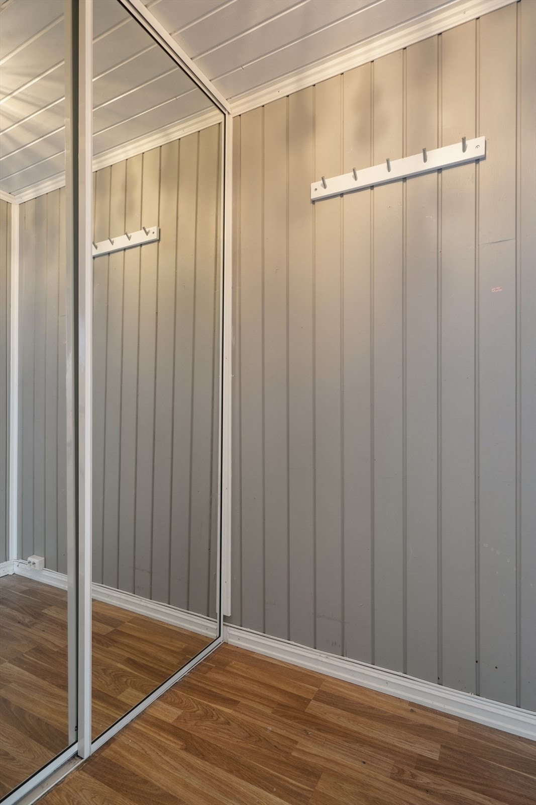 Man ønskes velkommen inn i en entré utstyrt med skyvedørsgarderobe som gir god lagringsplass. Galleribilde