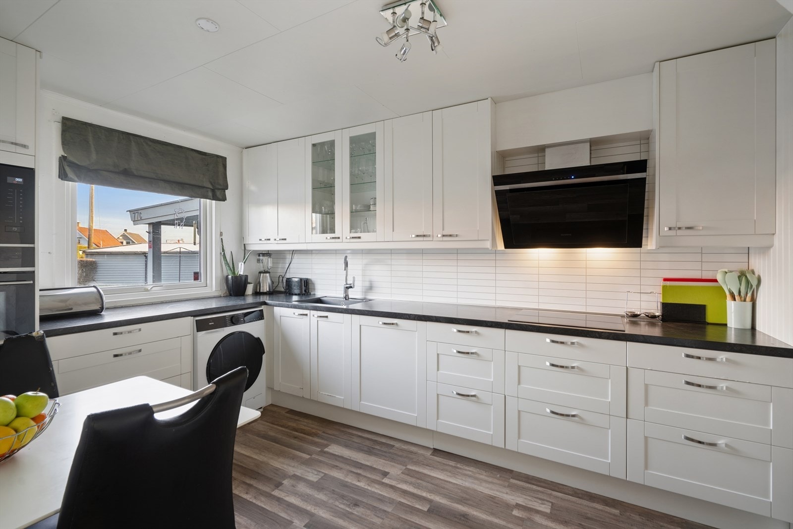 Kjøkkenet ble byttet i 2018 og er tidløst innredet med hvite, profilerte fronter og mørk benkeplate i laminat. Et stort og godt kjøkken hvor man har rikelig med skap- og skuffeplass, samt gode arbeidsflater på benk. Galleribilde