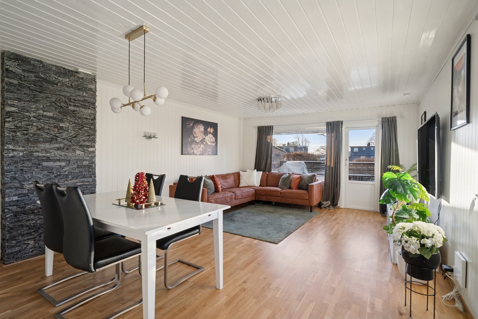 Stuen er romslig og innbydende med store vindusflater som gir godt med naturlig lys. Her har man god plass til å møblere med både sofa- og spisegruppe. Galleribilde