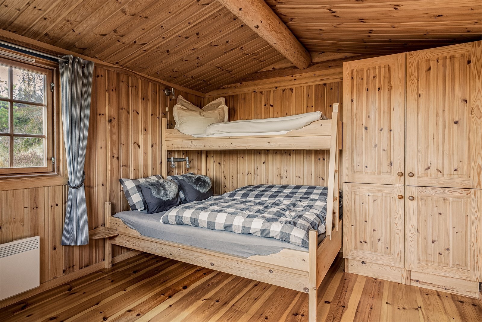 Anneksets' sove-/oppholdsrom er innredet med en stor familiekøye og et praktisk garderobeskap. Panelovn på vegg sørger for at man kan ha en behagelig temperatur. Galleribilde