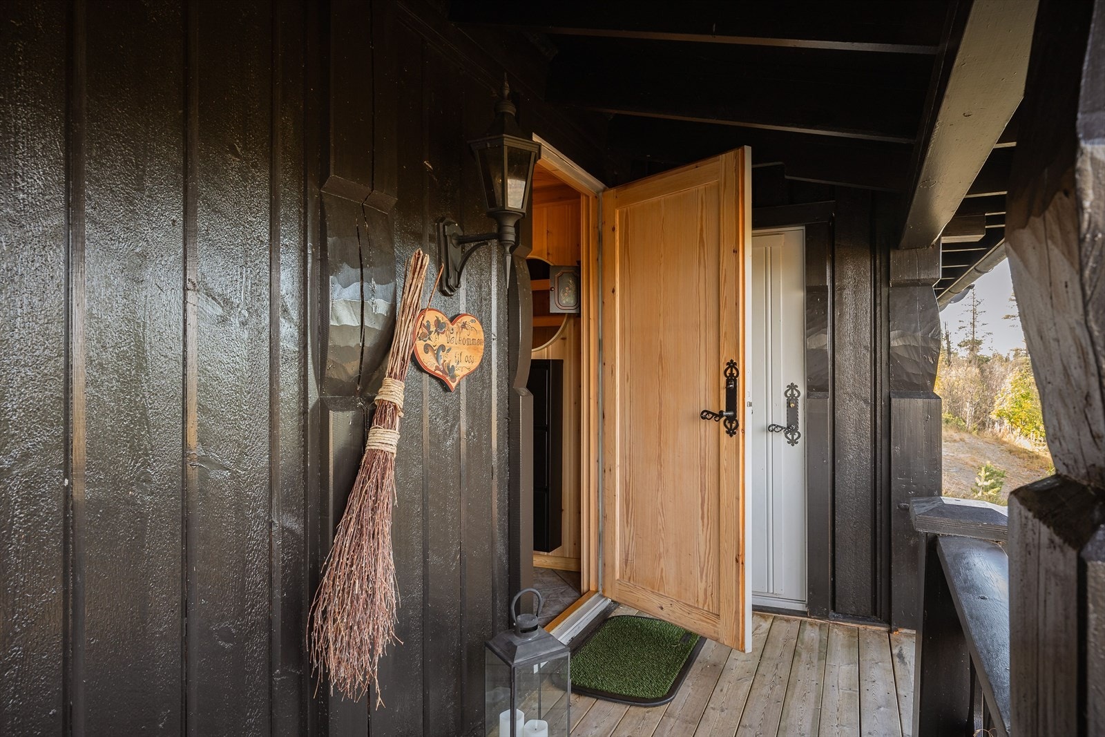 Det overbygde inngangspartiet skjermer godt for vær og vind, og med den ene boden rett ved døren kan man gå tørrskodd ut for å hente f.eks. ved. Galleribilde