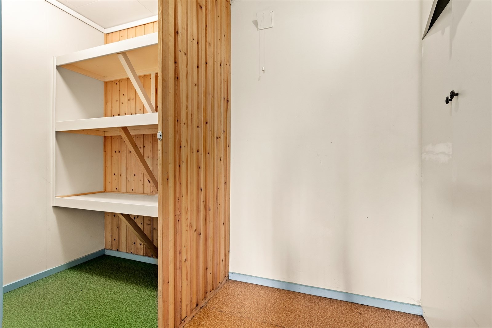 Bodareal i kjellar med garderobeskåp og praktiske hyller. Galleribilde